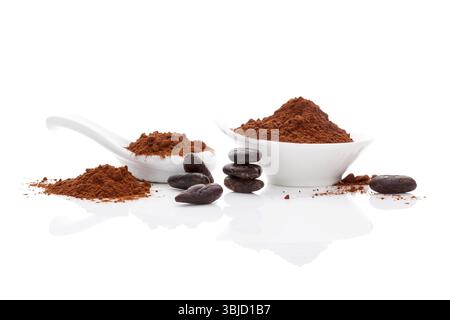 Kakaobohnen und Kakaopulver in weißer Schüssel und weißem Löffel auf weißem Hintergrund. Gesundes Superfood Stockfoto