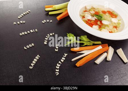 Gesunde Gemüsesuppe mit verschiedenen Gemüsesorten und Wörtern aus Alphabetnudeln. Gesunde Ernährung Gastronomie Hintergrund Stockfoto