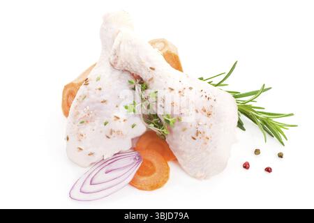 Zwei rohe Hähnchenschenkel mit frischem Gemüse isoliert auf weiß Stockfoto