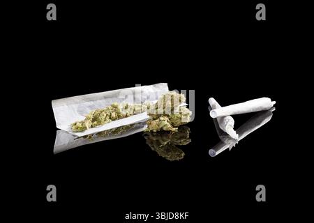 Marihuana-Hintergrund. Cannabis Zigarettengelenk, Knospen und Hanfblätter isoliert auf schwarzem Hintergrund. Suchtmittel oder Alternativmedizin Stockfoto