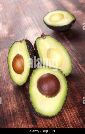 Köstliche frische, reife geschnittene Avocados auf hölzernem Hintergrund. Gesunde Ernährung Stockfoto
