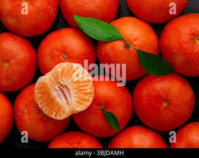 Hintergrundfoto der geschälten Clementine mit Mandarinen im Hintergrund. Stockfoto