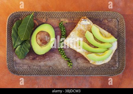 Geschnittene Avocado auf Brot mit frischem grünem Pfeffer von oben Stockfoto