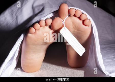 COVID19-Opfer im Leichenschauhaus. Leiche, Leiche bedeckt mit weißer Decke Stockfoto