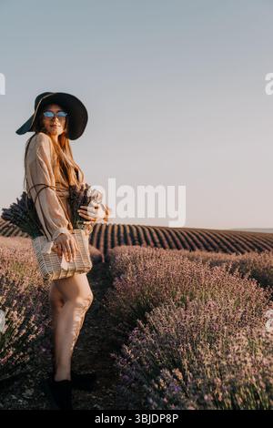 Frau in einem Lavender-Feld, die Blumen hält Stockfoto