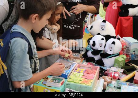 Sofia, Bulgarien. Juni 2025. Kinder kaufen chinesische Kulturprodukte beim Asian Festival in Sofia, Bulgarien, 14. Juni 2025. ZUM THEMA „Feature: Bunte Kulturen glänzen beim Asian Festival in Sofia“ Credit: LIN Hao/Xinhua/Alamy Live News Stockfoto