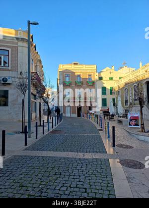 Sesimbra, Portugal. 20. Dezember 2024 Ein dreistöckiges Gebäude mit klassischen Azulejo-Keramikfliesen, Balkonen mit grünen Girlanden, neben narro Stockfoto