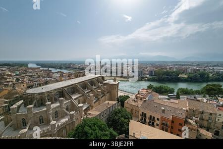 Panoramablick auf Tortosa, den Fluss Ebro, der durch das Stadtzentrum fließt, und die alte Kathedrale an sonnigen Tagen Stockfoto