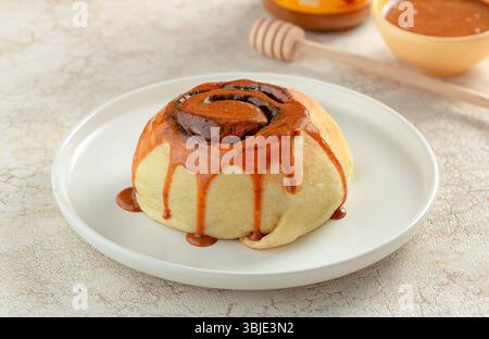 Zimt-Dessert mit Karamellglasur, weiches Brötchen mit süßem Sirup. Stockfoto