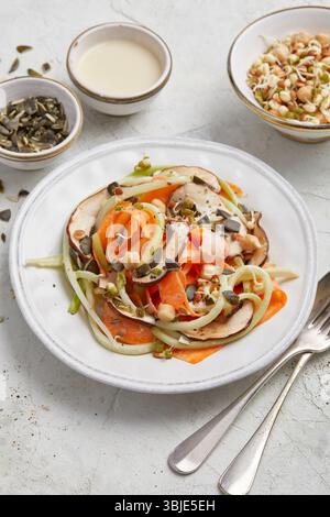 Gemüsespaghetti mit Zitrone und Salbei. Eine leichte und gesunde Gemüsemahlzeit, serviert auf einem runden weißen Teller. Ideal für sauberes Essen oder schnelle Mahlzeiten. Stockfoto