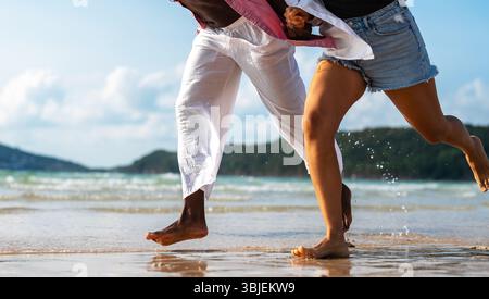 Reines Glück. Ein junges, vielseitiges, multiethnisches Paar genießt jeden Moment ihres tropischen Urlaubs Stockfoto