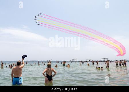 Santiago de La Ribera, San Javier, Spanien. Juni 2025. Das Kunstflugteam der spanischen Luft- und Raumfahrtstreitkräfte namens Patrulla Águila (Eagle Patrol), das am 4. Juli 1985 gegründet wurde, feiert sein 40-jähriges Bestehen und das Ende seiner Zeit mit dem Flugzeug Casa C-101 Aviojet beim Übergang zu Pilatus PC-21 Turboprop. Über die Strände des Mar Menor mit patriotischem Rauchpfad mit Publikum im Meer, mit einem winkenden Abschied Stockfoto
