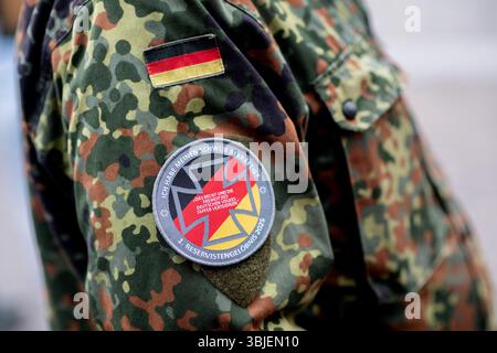 Vechta, Deutschland. Juni 2025. Ein Reservist trägt ein Abzeichen mit der Aufschrift „I have re affirmed my Eid“ und dem Zusatz „1st Reservist Pledge 2025“ auf seiner Uniform während eines namentlichen Anrufs der Reservist am National Veterans Day. An diesem Tag werden alljährlich der Dienst, das Engagement und die Leistungen von Soldaten der Bundeswehr geehrt, die im Einsatz sind oder waren. Quelle: Hauke-Christian Dittrich/dpa/Alamy Live News Stockfoto