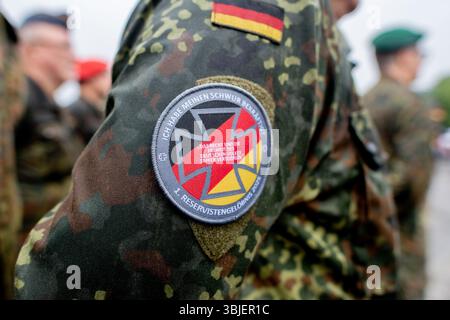 Vechta, Deutschland. Juni 2025. Ein Reservist trägt ein Abzeichen mit der Aufschrift „I have re affirmed my Eid“ und dem Zusatz „1st Reservist Pledge 2025“ auf seiner Uniform während eines namentlichen Anrufs der Reservist am National Veterans Day. An diesem Tag werden alljährlich der Dienst, das Engagement und die Leistungen von Soldaten der Bundeswehr geehrt, die im Einsatz sind oder waren. Quelle: Hauke-Christian Dittrich/dpa/Alamy Live News Stockfoto