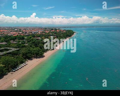 Atemberaubende Luftperspektive, die Balis glitzernde Küste und üppiges Grün enthüllt. Stockfoto