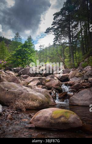 Ein HDR-Bild im Hochformat im Sommer eines kleinen Wasserfalls, der flussabwärts in einem Felsbrocken in Wester Ross, Schottland, tropft. Juni 2009 Stockfoto