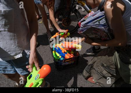 Barcelona, Spanien. Juni 2025. Die Demonstranten verteilen Wasserpistolen, ein Symbol für den Kampf gegen den Massentourismus zu Beginn einer Demonstration. Mehr als tausend Demonstranten marschierten durch das Zentrum Barcelonas zur Basilika Sagrada Família gegen die touristische Gestaltung Barcelonas, die prekäre Arbeitsplätze im Dienstleistungssektor schafft und die Immobilienpreise erhöht. Quelle: SOPA Images Limited/Alamy Live News Stockfoto