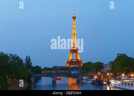 Paris, Frankreich - 08. Juni 20235 Blick auf den Eiffelturm, der hell vor dem dunkelblauen Nachthimmel in Paris leuchtet. Berühmtes Reiseziel. Stockfoto