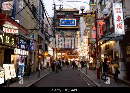 Nachtansicht auf china Town mit Werbetafeln, Marktständen und Menschen, die durch die Straßen von Yokohama, Japan, spazieren gehen Stockfoto