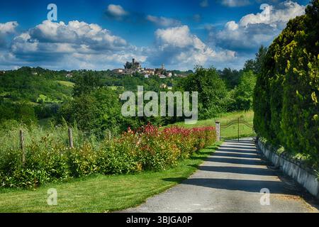 Straße, die zu einem Dorf auf dem Hügel und einer Burg führt, Trisobbio, Monferrato, Alessandria, Piemont, Italien Stockfoto