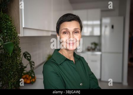 Porträt der lächelnden Reifen Frau. Glücklicher, entspannter weiblicher Blick in die Kamera, natürliche Schönheit Selbstakzeptanz Stockfoto