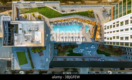 Aus der Vogelperspektive auf einen Dachpool und einen modernen Lounge-Bereich im Freien in einem Wohnhochhaus. Stockfoto