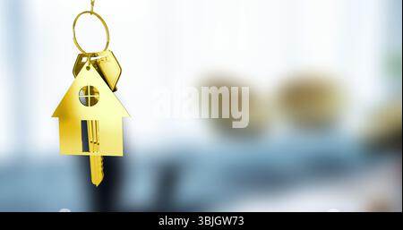 Hängender goldener Schlüsselanhänger in häuslicher Form auf rundem Schlüsselanhänger in hellem Innenraum mit eingefügtem Schlüssel Stockfoto