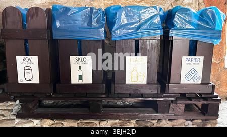 Vier hölzerne Mülltonnen für getrenntes Abwerfen, geschrieben ,,KOV'' ,,SKLO'' ,,PLAST'' ,,PAPIER'' in slowakischer Sprache und englischer und polnischer Übersetzung Stockfoto