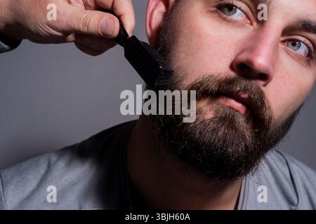 Friseur hält Friseurwerkzeuge. Friseur. Mann mit Friseurwerkzeugen. Der Mann Schnitt die Haare mit einer Friseurschere. Männerfrisur im Friseur. Friseurschere Stockfoto