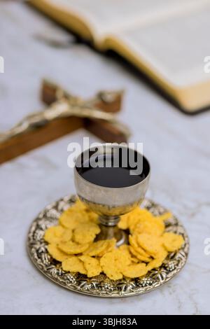 Kommunionelemente, einschließlich Weinbrot, sind sorgfältig auf silbernem Tablett angeordnet und schaffen eine friedliche Atmosphäre in der Kirche Stockfoto