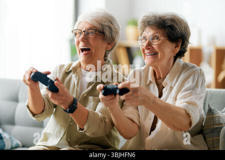 Zwei ältere Freundinnen oder Schwestern spielen zu Hause Videospiele. Stockfoto