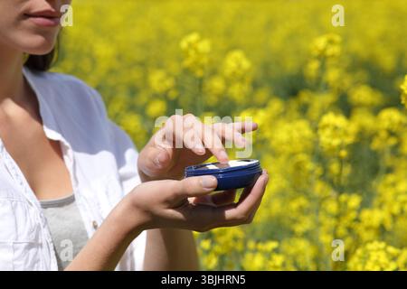 Nahaufnahme einer Frau Hände, die einen sonnigen Tag mit Feuchtigkeitscreme in der Hand hält Stockfoto