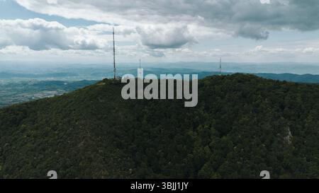 Telekommunikationstürme auf dem Ovcar Bergrücken, umgeben von bewaldeten Hügeln. Die Natur des Landes Serbien im Frühling. Luftaufnahme von der Drohne. Stockfoto