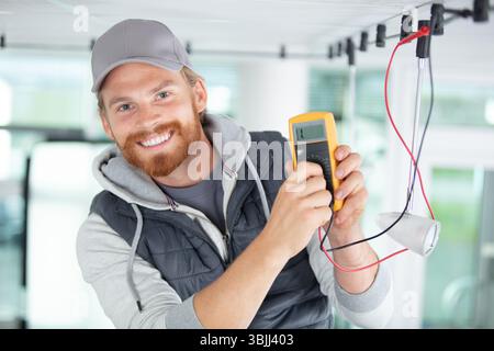 Elektriker prüft die Verkabelung am elektrischen Schalter Stockfoto