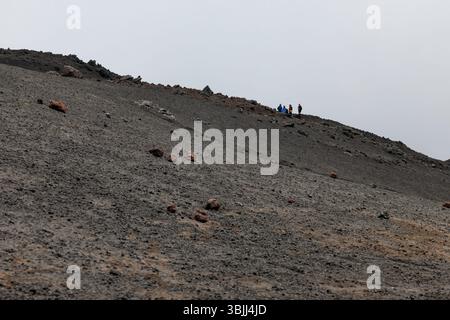 Gruppe von Wanderern, die beim Besteigen des Ätna eine Pause einlegen Stockfoto
