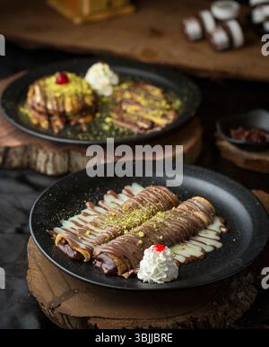 Schokoladen-Kreppteller mit Creme und Premium-Schokolade, luxuriöses Dessert auf dunklem Hintergrund. Stockfoto