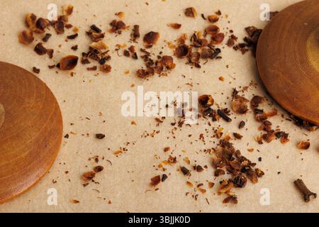Krümel und Gewürze mit Holzmaterialien auf Papierhintergrund, Draufsicht, Stillleben Stockfoto