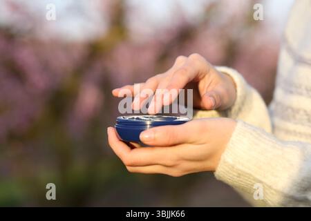 Nahaufnahme einer Frau, die einen Feuchtigkeitsbehälter auf einem Feld hält Stockfoto