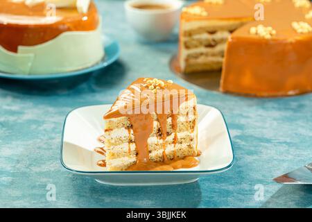 Karamell-Kuchenscheibe mit ganzer Karamellbrot und Sauce, reichhaltiges westliches Dessert. Stockfoto