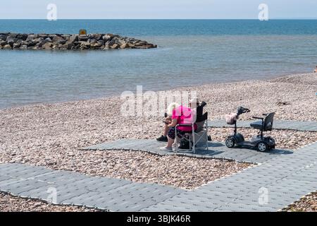 Juni 2025. Die barrierefreien Matten in Sidmouth, Devon am Sidmouth Beach ermöglichen es Rollstuhlfahrern, Rollstühlen und Müttern mit Kinderwagen, das herrliche Wetter zu genießen. Photo Central/Alamy Live News Stockfoto