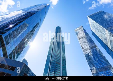 Flacher Blick auf moderne Wolkenkratzer vor blauem Himmel. Reflektierende Wolkenkratzer, Bürogebäude. Stockfoto
