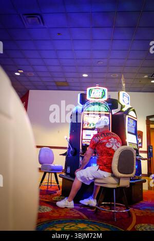 13. MAI 2025 - Reno, NV, USA - Ein Spieler in einem Casino in Nevada, USA, der die Spielautomaten anputzt. Sie zeigen die hellen Lichter und den Spaß der Maschinen. Stockfoto