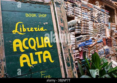 Gemalte Schilder und alte Bücher im Acqua Alta Bookshop, gut bekannte Buchhandlung in der Sestiere von Castello, Venedig, Venetien, Italien Stockfoto