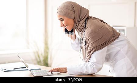 Seitenansicht einer Ärztin, die telefonisch einen Termin vereinbart hat Stockfoto