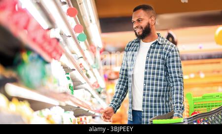 African American Guy Kauf Von Lebensmitteln In Der Nähe Von Regal In Supermarkt Stockfoto
