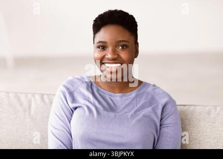 Porträt einer jungen afroamerikanischen Frau, die selbstbewusst lächelt Stockfoto