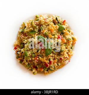 Couscous mit gekochtem Gemüse wie Karotten, Zucchini, Paprika und frischem Basilikum. Veganer Salat. Gesunde und vegetarische Lebensmittel. Direkt darüber. Stockfoto
