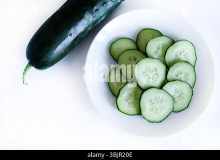 Ganze und geschnittene Gurke auf weißem Hintergrund. Salatzutat. Gesunde Ernährung. Direkt darüber. Stockfoto