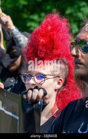 Ein Teilnehmer mit einem roten mohawk hält ein Banner während der Warschauer Pride Parade (Parada Równości) in Warschau, Woiwodschaft Masowien, Polen im Juni 2025 Stockfoto