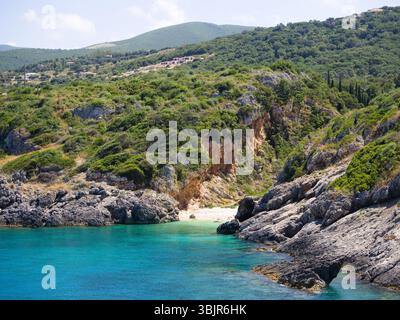Winziger Sandstrand umgeben von felsigen Klippen und pulsierendem Meer auf der Insel Zante, Griechenland Stockfoto